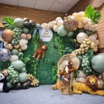 Panou decorativ pentru petrecere tematica safari cu ghirlanda organica din baloane verzi, aurii si animal print, frunze tropicale si animale de plus